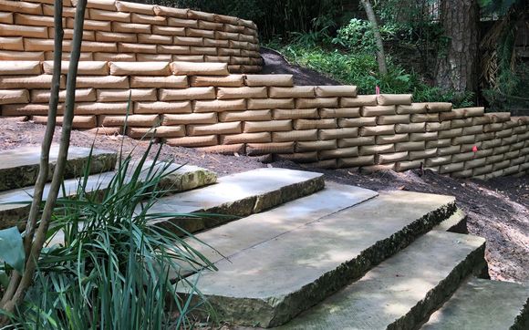 stone walkway with a concrete bag retaining wall showing the answer to do concrete bag retaining walls last as only being done so in ideal weather conditions